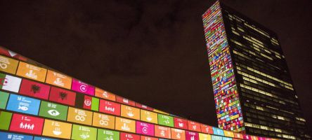 Het gebouw van de VN in New York met de logo's van de Duurzame Ontwikkelingsdoelen